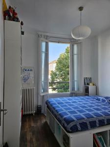 - une chambre avec un lit et une grande fenêtre dans l'établissement Maison de ville avec jardin., à Courbevoie