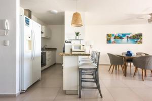 een keuken met een witte koelkast en een tafel bij ☆BLUE DREAM- Beachfront/ 6 pax/ Excellent WIFI☆ in Cancun