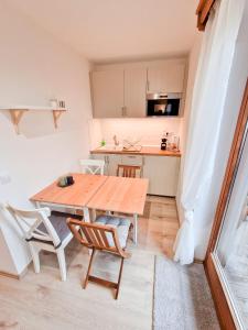 a small kitchen with a wooden table and chairs at LOBE Apartment in Bad Mitterndorf