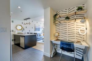a kitchen and living room with a counter and a table at Coastal Creative Condo in Victoria