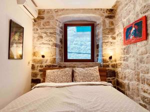 een slaapkamer met een bed in een kamer met een raam bij The Way Up in Kotor