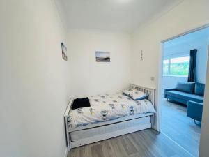 a bedroom with a bed and a blue couch at 2 bedroom holiday home in the heart of west wales in St Clears