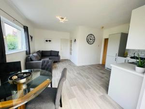 a living room with a glass table and a kitchen at 2 bedroom holiday home in the heart of west wales in St Clears