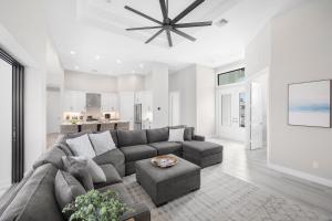 Una sala de estar con un sofá gris y una mesa. en Marco Coastal Luxury | Pool, Spa and Outdoor Kitchen, en Marco Island