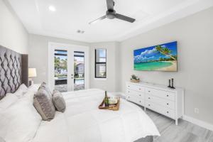 1 dormitorio blanco con 1 cama blanca y vestidor blanco en Marco Coastal Luxury | Pool, Spa and Outdoor Kitchen, en Marco Island 44 fotos más