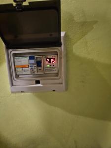 Un reloj despertador digital en una pared verde en Valentyna Aparts El Chalten 4, en El Chaltén