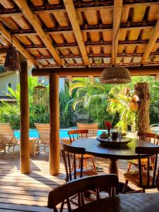 a patio with a table and chairs and a pool at Vila Pitanga Trancoso in Trancoso