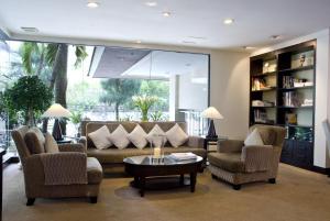 a living room with two couches and a table at Kantary House Hotel, Bangkok in Bangkok