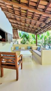 una sala de estar con sofás y techo de madera. en Vila Pitanga Trancoso, en Trancoso
