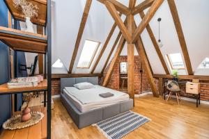 two pictures of a bedroom with a bed and a loft at Przytulny Apartament Z Wieżą in Gliwice