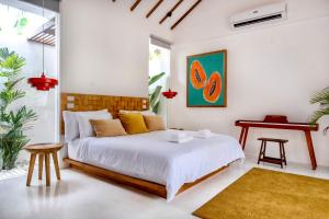 a white bedroom with a bed and a table at Manao Villas in General Luna