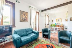 ein Wohnzimmer mit einem blauen Sofa und 2 Stühlen in der Unterkunft Vicolo Parchetto 9 in Ferrara