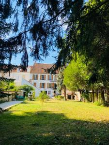 ein großes Haus in einem Hof mit Rasenfläche in der Unterkunft Homelière in Villeneuve-sur-Bellot