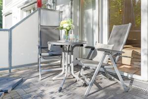 einen Tisch und zwei Stühle auf einer Terrasse in der Unterkunft Strandvilla Augustusbad Morgenstern in Scharbeutz