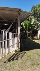 a porch of a house with a white fence at Finca el recuerdo Arbelaence in Arbeláez