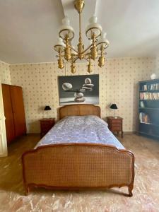 a bedroom with a large bed and a chandelier at Homelière in Villeneuve-sur-Bellot