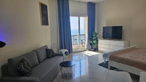 a living room with a couch and a television at Full Sea view studio in Ras al Khaimah