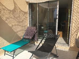 two chairs and a hammock on a porch at Très joli studio 4 personnes avec terrasse front de mer in Leucate