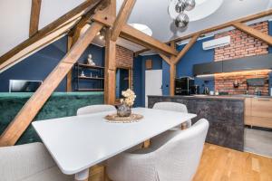 a dining room with a white table and chairs at Uroczy Apartament Gliwice in Gliwice +28 photos