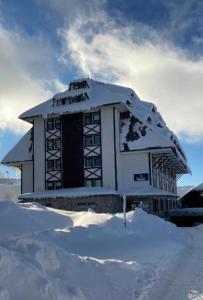a building covered in snow on top of a pile of snow at Kopaonik Župa 505 in Kopaonik