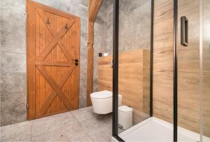 a bathroom with a wooden door and a toilet at Uroczy Apartament Gliwice in Gliwice