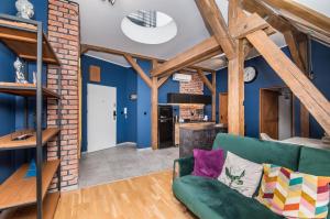 a living room with blue walls and a green couch at Uroczy Apartament Gliwice in Gliwice