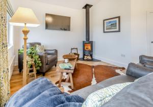 a living room with a couch and a wood stove at The Heritage Retreat in Monknash