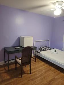 een kamer met een bureau, een bed en een stoel bij Kanata Prime Location, Ottawa in Ottawa