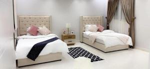 1 dormitorio con 2 camas y espejo en مساكن الدار 1 en Abha