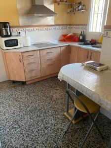 kuchnia z drewnianymi szafkami i stołem w obiekcie Apartamento de habitaciones privadas en el centro de Málaga w Maladze