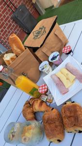 una mesa cubierta con una caja de pan y bollería en La Villa Juliette L'Etoile Filante en Biville-sur-Mer