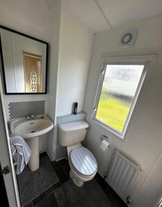 a small bathroom with a toilet and a sink at 2 Bedroom Caravan With Sea Views in Eastchurch