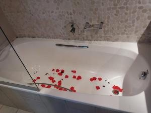 a bath tub with red flowers on the side of it at Emufuleni river logde in Vanderbijlpark +124 photos