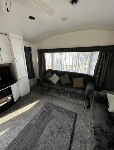 a living room with a couch and a window at 2 Bedroom Caravan With Sea Views in Eastchurch