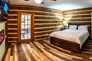 にあるSerenity on Seven Acres - Luxurious Log Cabinの木製の壁のベッドルーム(ベッド付)