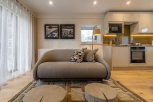 ein Wohnzimmer mit einem Sofa und einer Küche in der Unterkunft The Corner Cottage, Romantic 5* for 2, Windermere in Windermere