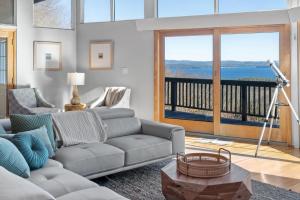 uma sala de estar com um sofá e uma grande janela em Lake Winnipesaukee & Gunstock Ski Mountain Views em Gilford