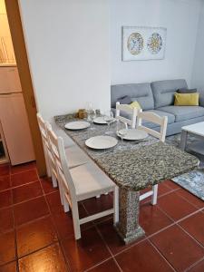 comedor con mesa, sillas y sofá en Apartamento Costa Norte, en Porto Moniz
