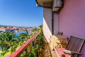 a balcony with a table and chairs and a view of a harbor at Apartments and Rooms Darinka in Vrboska