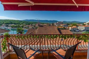 two chairs and a table on a balcony with a view at Apartments and Rooms Darinka in Vrboska