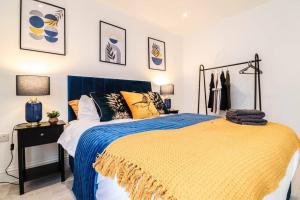 a bedroom with a bed with a blue and yellow blanket at Dulwich House - Long Stay Offer - 2 mins to Station in London