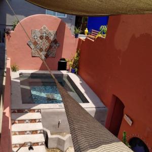 a house with a swimming pool with a rope reaching up to a building at Riad Lola in Sayulita