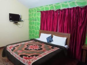 sypialnia z łóżkiem z czerwoną zasłoną w obiekcie Crystal homestay w mieście Utakamand