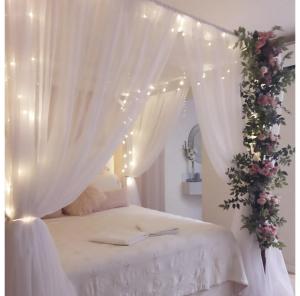 uma cama branca com um dossel com flores e luzes em Live House Boutique Hotels em São Paulo