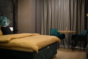 a bedroom with a bed and a table and chairs at Nia Lux Apartman in Belgrade