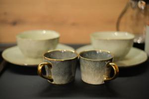 two coffee cups sitting on a table with plates at Nia Lux Apartman in Belgrade