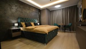 a bedroom with a bed with a green headboard and a table at Nia Lux Apartman in Belgrade +11 photos