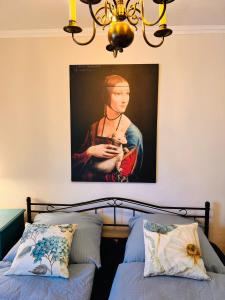 una pintura de una mujer sosteniendo un gato en un dormitorio en Ferienwohnung Emma - WLAN, Küche, TV, Bad, ca 15 Min zum Europa Park, en Malterdingen