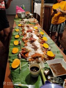una mesa larga con un montón de comida. en Siargao Vibes Private Resort en Bago