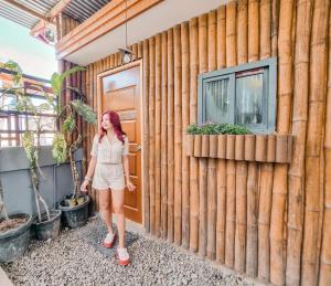 una mujer parada frente a un edificio de madera en Siargao Vibes Private Resort en Bago